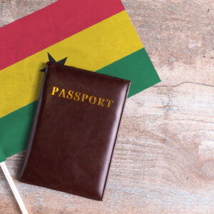 Passport and a Ghana flag on a wooden background. Travel concept
